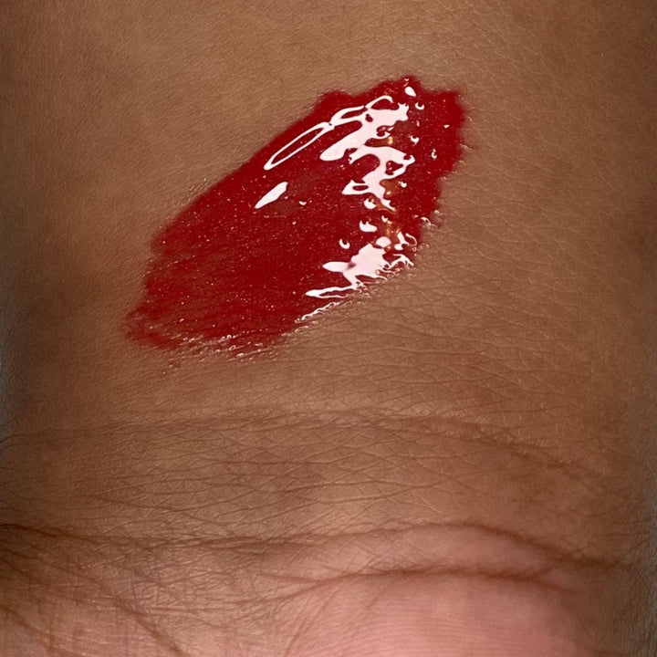 Red lipgloss swatch on Black woman, clean environmentally friendly beauty product